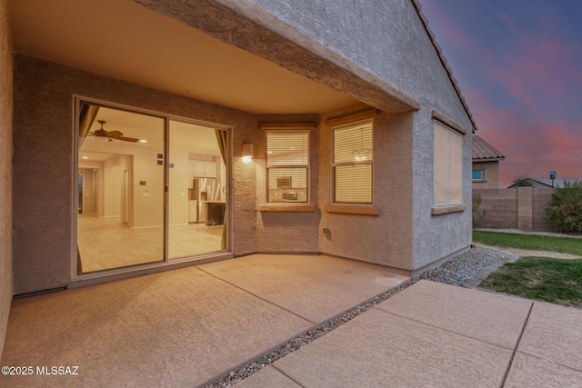 exterior entry at dusk featuring a patio area