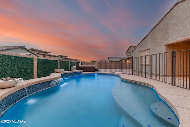 pool at dusk featuring pool water feature