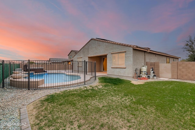 pool at dusk with a patio and a lawn