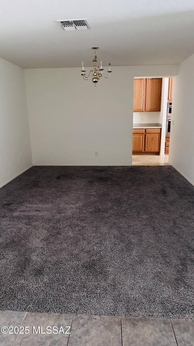 unfurnished living room with a notable chandelier and carpet