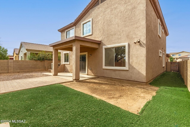 rear view of property with a patio area and a lawn