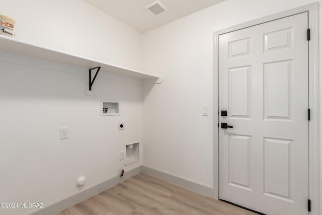 clothes washing area featuring hookup for a gas dryer, light hardwood / wood-style floors, hookup for a washing machine, and electric dryer hookup