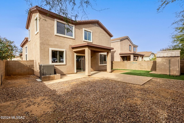 rear view of house with central AC, a patio, and a storage unit