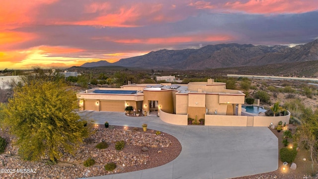 view of front of home featuring fence, a mountain view, a garage, solar panels, and a chimney