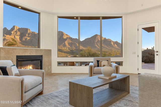 interior space with a glass covered fireplace, a healthy amount of sunlight, and a mountain view