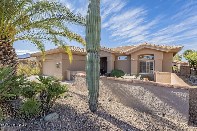 view of front of home featuring a garage, fence, and stucco siding