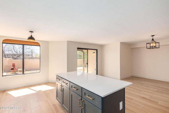 kitchen featuring an inviting chandelier, a center island, and hanging light fixtures