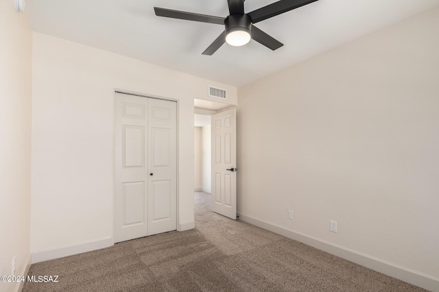 unfurnished bedroom featuring carpet flooring, ceiling fan, and a closet