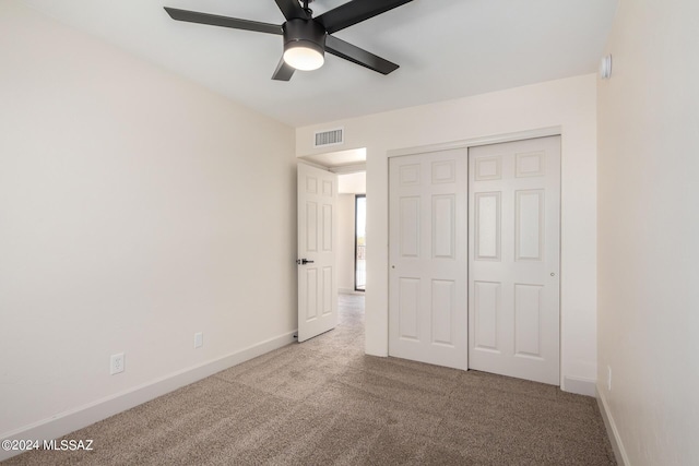 unfurnished bedroom featuring light carpet, ceiling fan, and a closet