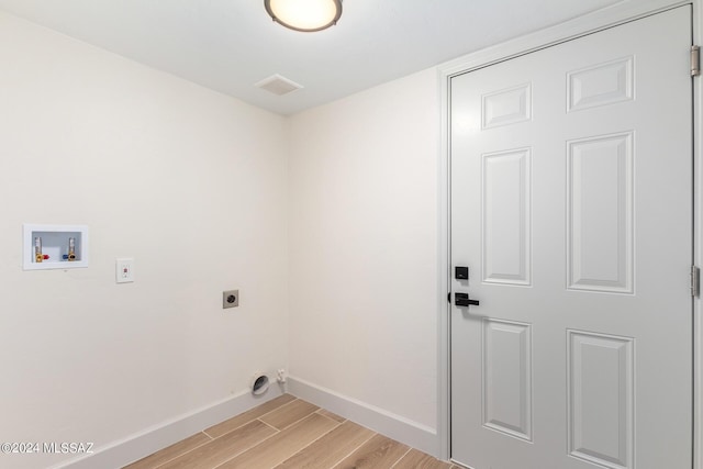 washroom with hookup for an electric dryer, washer hookup, and light hardwood / wood-style flooring