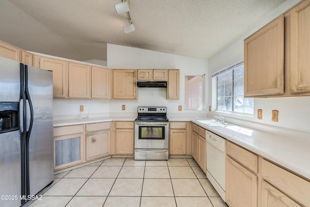 kitchen featuring stainless steel appliances, light brown cabinetry, and light tile patterned floors