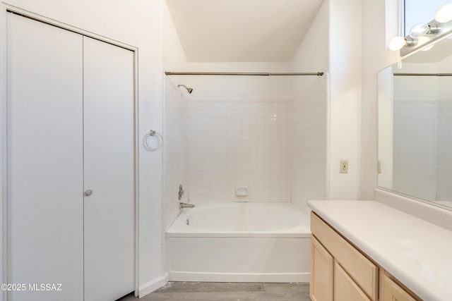 bathroom featuring tiled shower / bath, vanity, and wood-type flooring