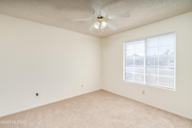 carpeted empty room featuring ceiling fan and a textured ceiling