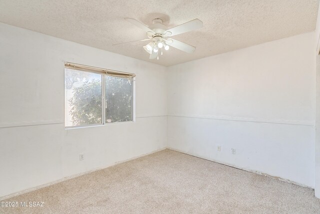 carpeted empty room with ceiling fan and a textured ceiling