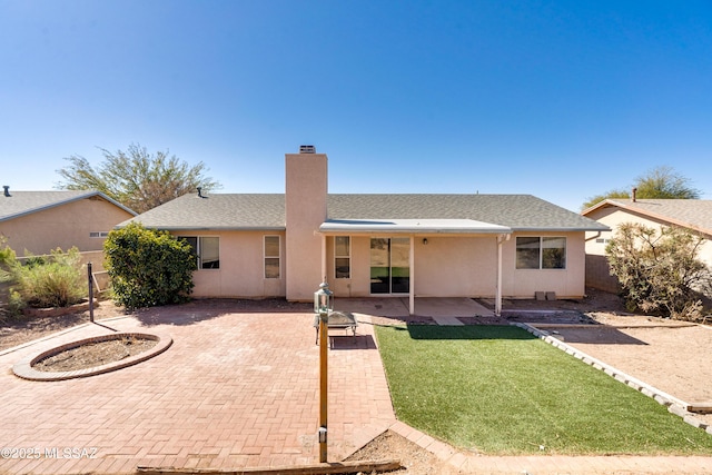 rear view of house with a yard and a patio area