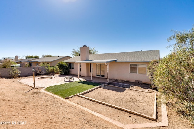 rear view of house featuring a fire pit and a patio