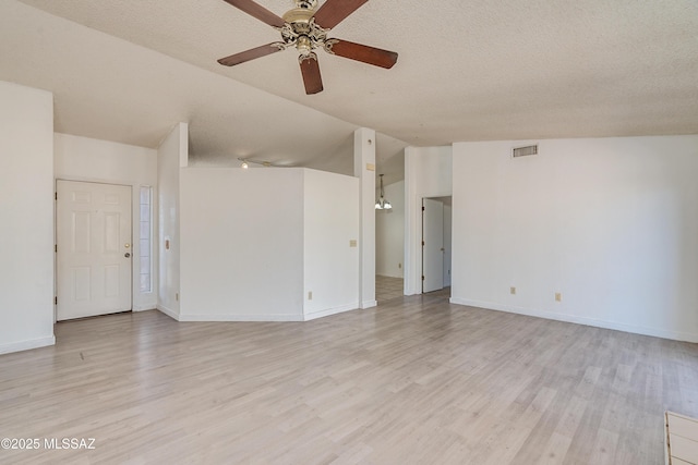 empty room featuring ceiling fan, lofted ceiling, light hardwood / wood-style flooring, and a textured ceiling