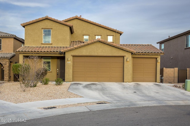 view of front of house featuring a garage, concrete driveway, a tile roof, and stucco siding