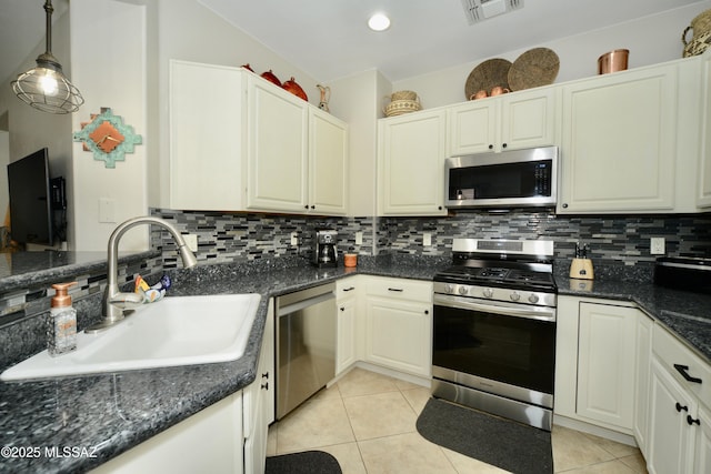 kitchen with appliances with stainless steel finishes, decorative light fixtures, sink, and backsplash