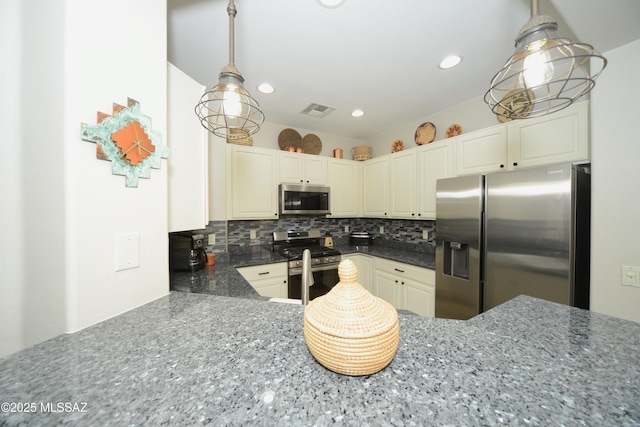 kitchen with backsplash, stainless steel appliances, and hanging light fixtures