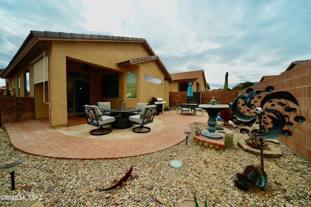 back of house with a fire pit and a patio area