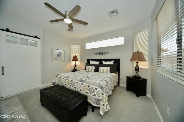 bedroom featuring ceiling fan and a barn door