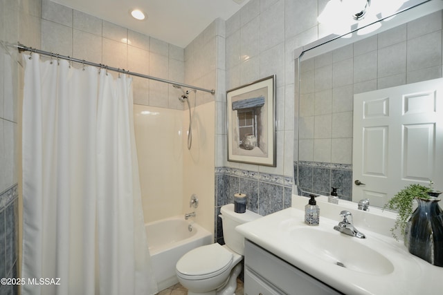 full bathroom with vanity, tile walls, shower / bathtub combination with curtain, and toilet