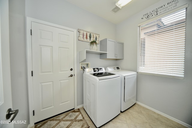 laundry area featuring independent washer and dryer, cabinets, and light tile patterned flooring