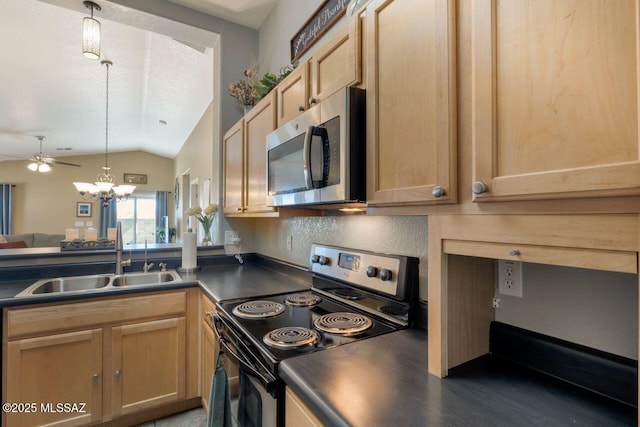 kitchen featuring lofted ceiling, stainless steel appliances, a sink, hanging light fixtures, and dark countertops