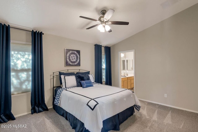 carpeted bedroom with baseboards, visible vents, connected bathroom, ceiling fan, and vaulted ceiling