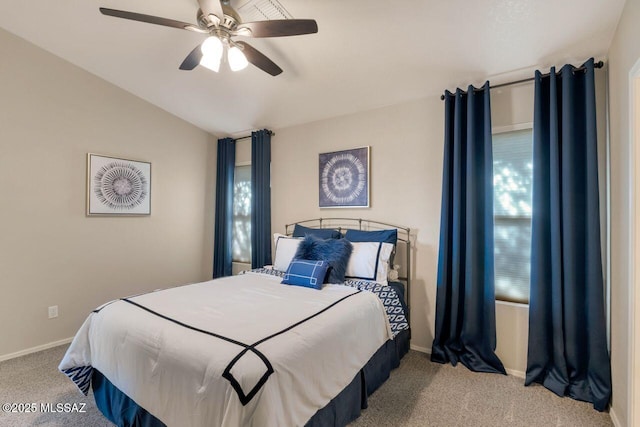 bedroom featuring a ceiling fan, light colored carpet, vaulted ceiling, and baseboards