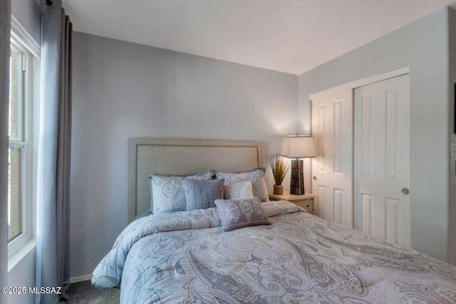 bedroom featuring a closet, carpet flooring, and baseboards