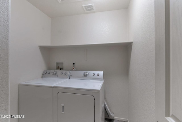 laundry area featuring laundry area, visible vents, and separate washer and dryer