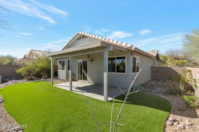 rear view of house with a patio, a yard, a fenced backyard, and stucco siding