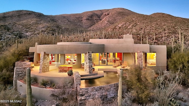 rear view of house with a patio and a mountain view