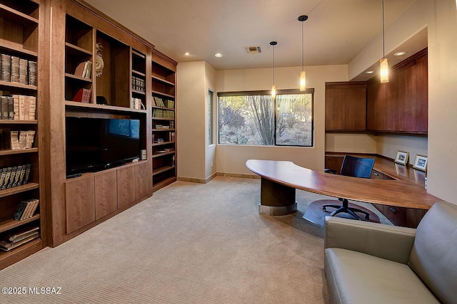 carpeted office space with built in desk