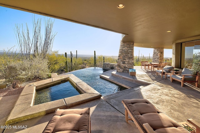 view of swimming pool featuring a patio, an outdoor stone fireplace, and an in ground hot tub