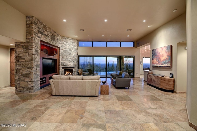 living room with a fireplace and a high ceiling