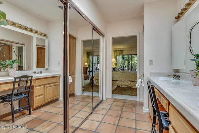ensuite bathroom with tile patterned floors, ensuite bath, and vanity