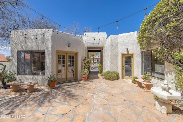 back of house featuring a patio area, french doors, and stucco siding