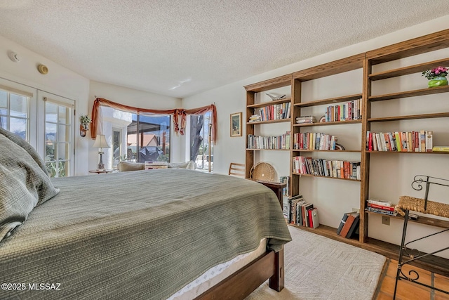bedroom with a textured ceiling and wood finished floors