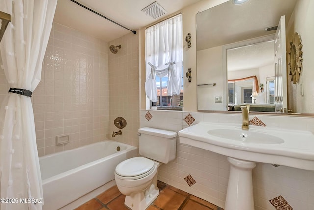 bathroom with toilet, shower / bath combo, tile patterned flooring, and visible vents