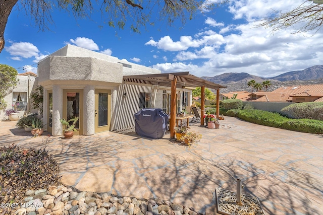 back of house with a patio, stucco siding, and a mountain view