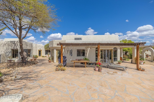 back of property with a patio area and stucco siding