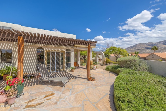 view of patio / terrace featuring a mountain view, a pergola, and fence