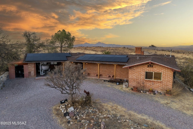 view of front facade featuring a mountain view and solar panels