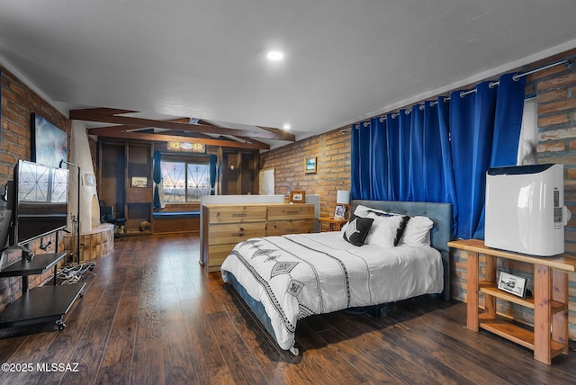 bedroom with brick wall and dark wood-type flooring