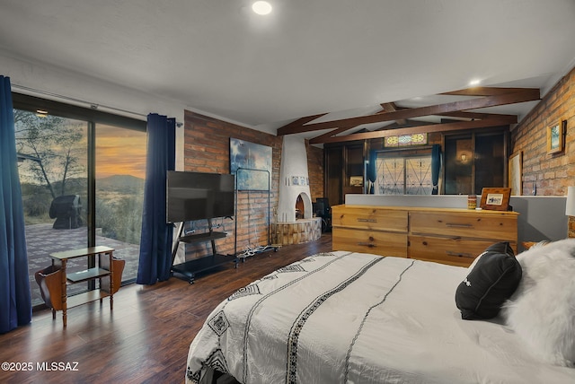 bedroom featuring beamed ceiling, brick wall, dark hardwood / wood-style flooring, and access to outside