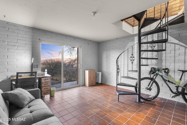 living room featuring tile patterned flooring and brick wall