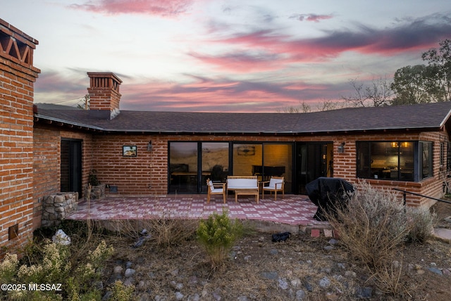 back house at dusk featuring an outdoor hangout area and a patio